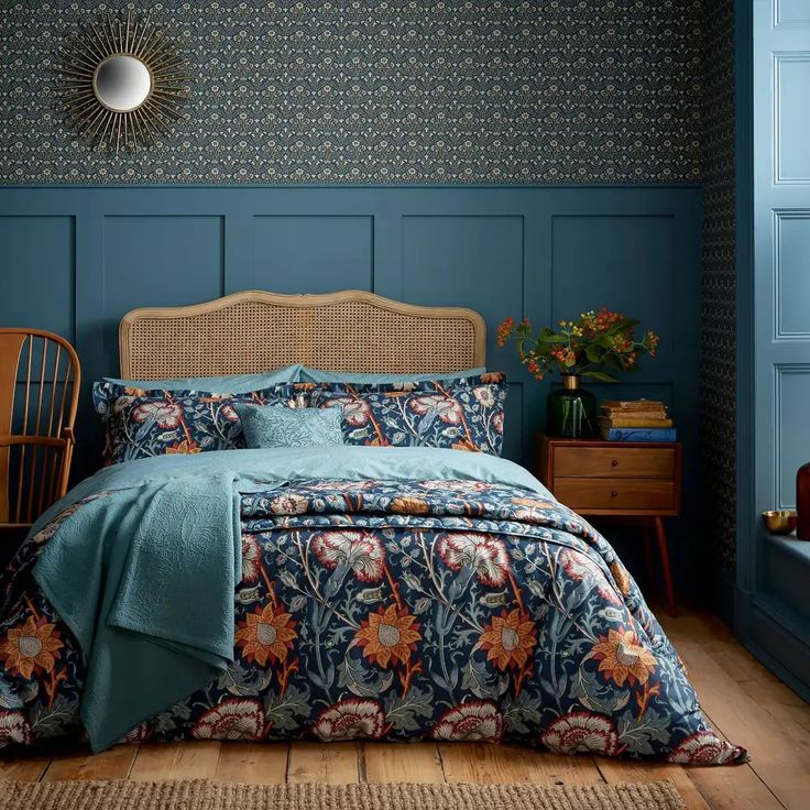 a bedroom with blue walls and bedding in the corner, along with a wicker chair