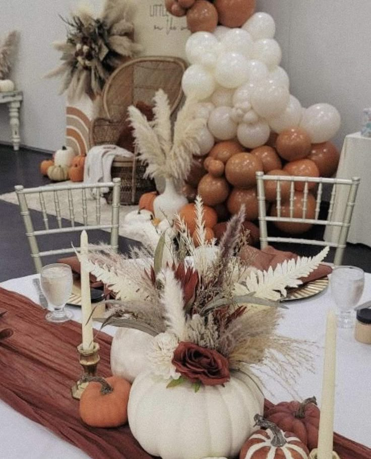 a table topped with lots of white pumpkins and other decorating items on top of it