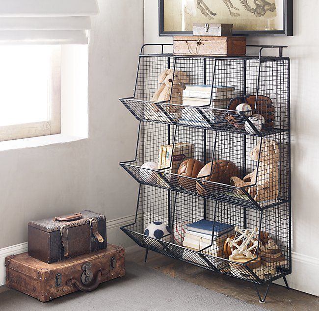 a metal shelf filled with lots of books and knickknacks next to a suitcase