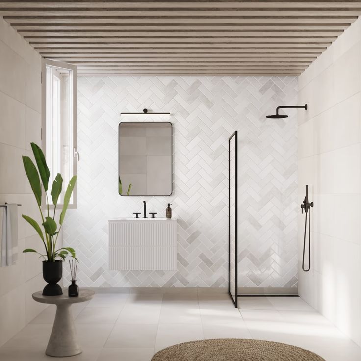 a modern bathroom with white tile walls and flooring is pictured in this image, there are two plants next to the shower