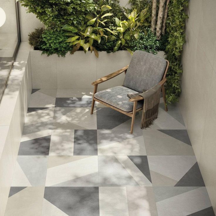 a chair sitting on top of a tiled floor next to a plant filled bathroom wall