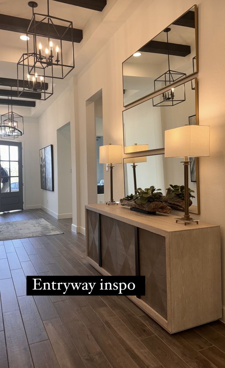 an entryway with mirrors and lights on the wall, wood flooring and wooden floors