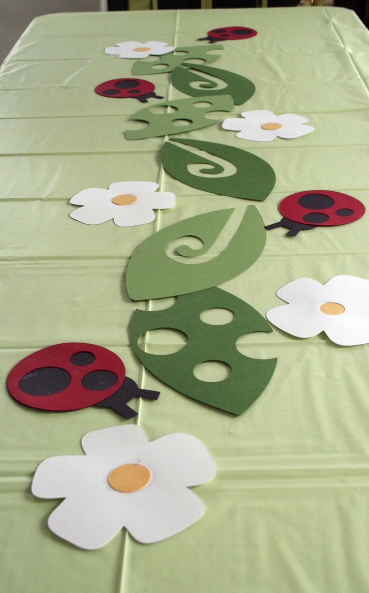 the table is decorated with paper flowers and ladybugs