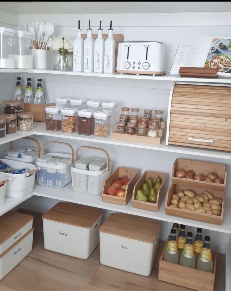 an organized pantry with lots of food and storage bins on the shelves in front of it