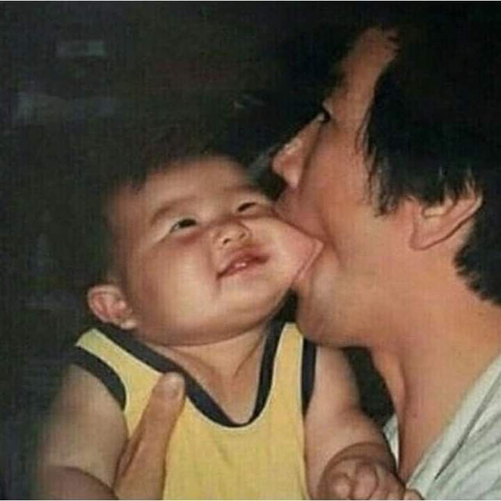 a man kissing a small child on the cheek