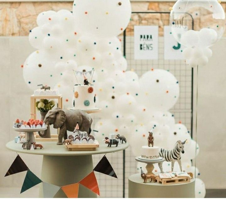 an elephant, zebra and giraffe themed dessert table with balloons in the background