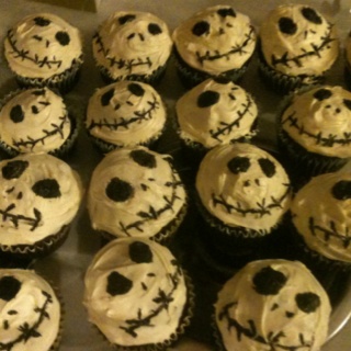 there are many cupcakes decorated with icing and spooky faces on them