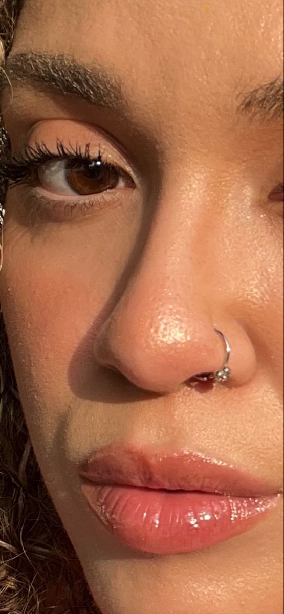 a close up shot of a woman's nose with piercings