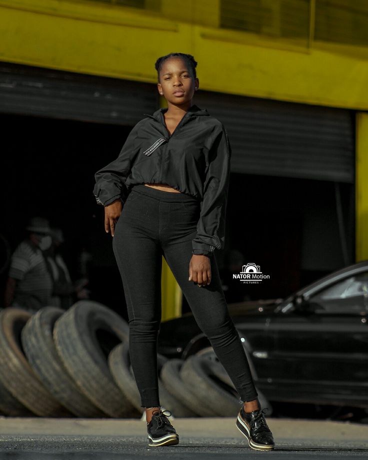 a woman is standing in front of some tires