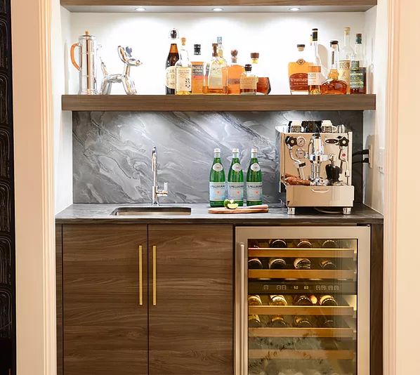 a wine rack with bottles and glasses on it in the corner of a kitchen area