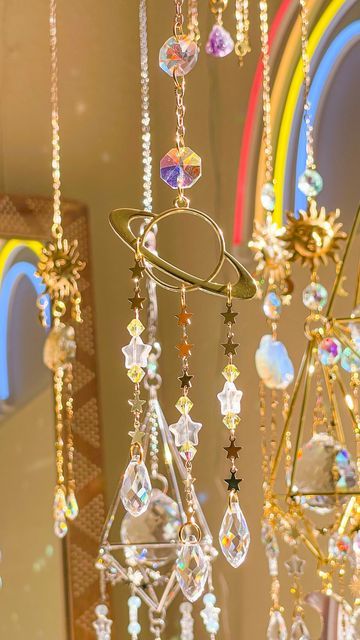 some very pretty chandeliers hanging from the ceiling in front of a rainbow colored window