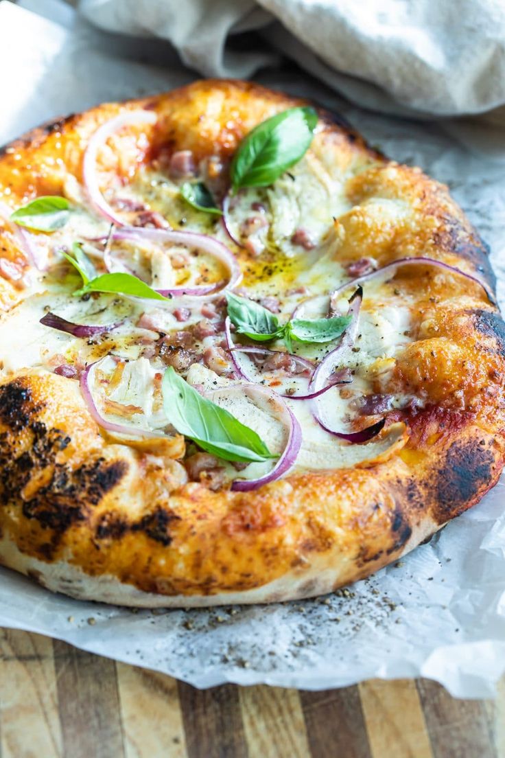 a pizza sitting on top of a wooden cutting board