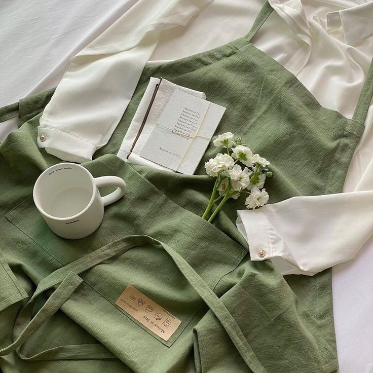 an open book, coffee cup and napkins on a bed with flowers in the middle