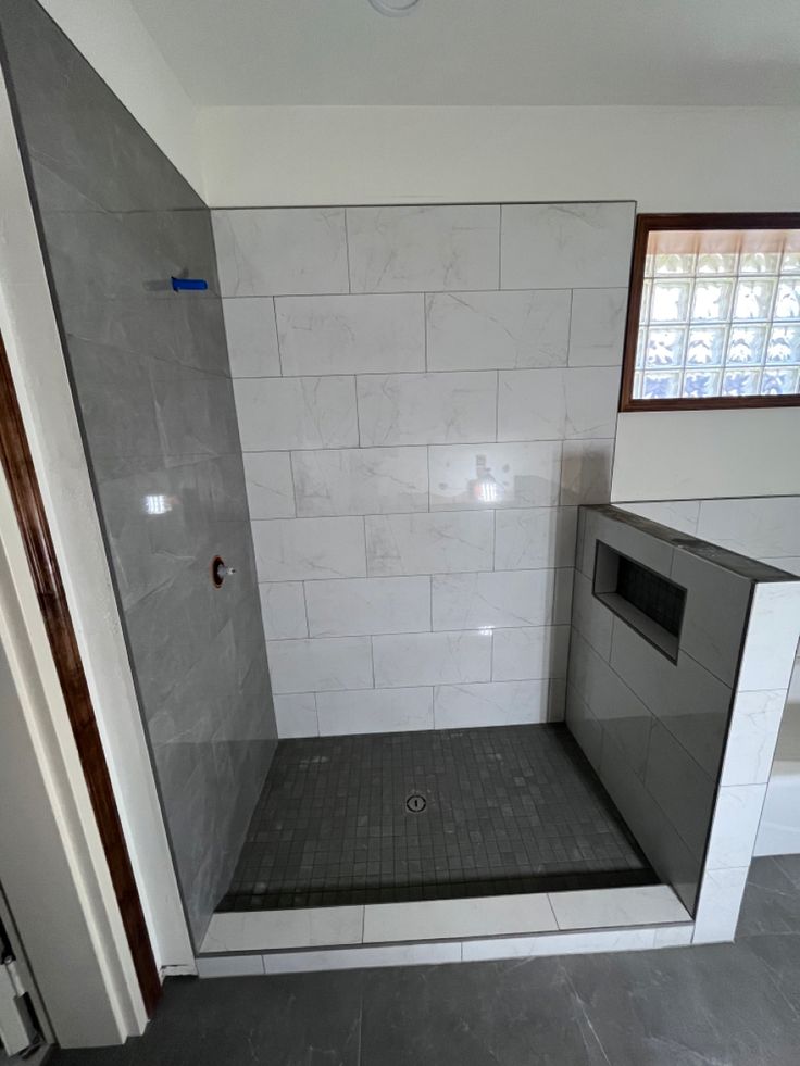 an empty bathroom with tiled walls and floor