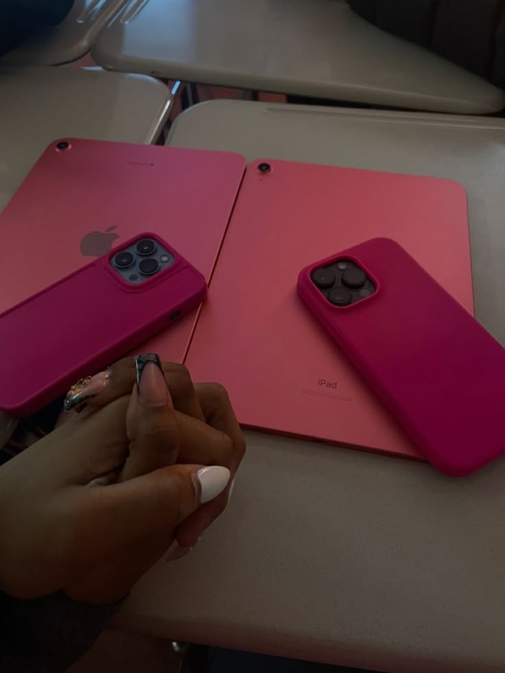 two pink iphones sitting on top of each other