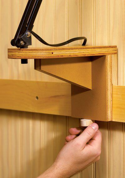 a hand is holding the door handle to an open drawer on a wood paneled wall