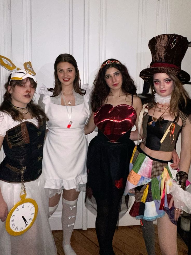 three women dressed up in costume posing for a photo with a clock on the wall behind them