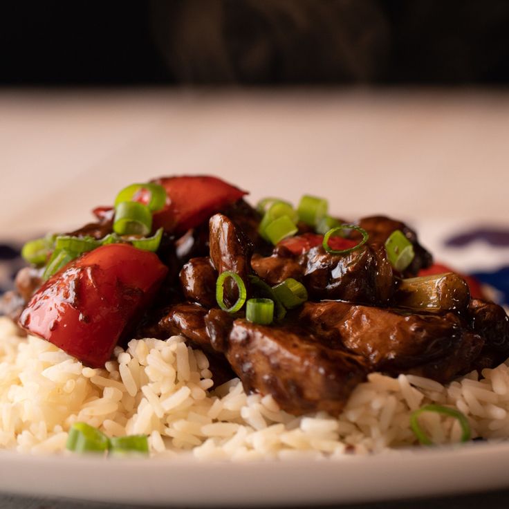 a white plate topped with rice and meat