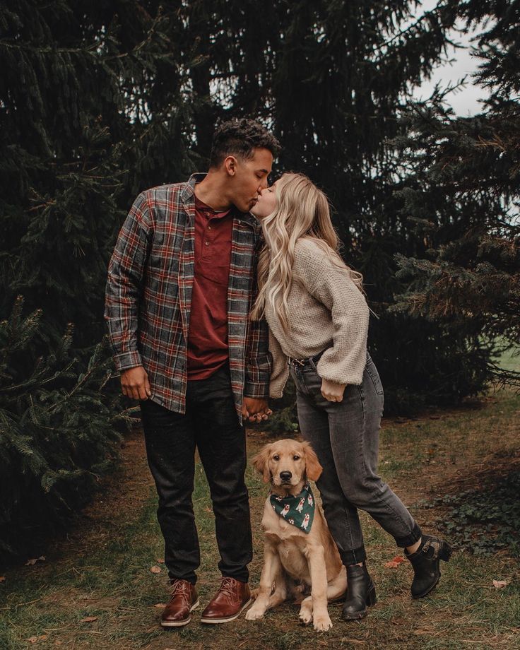 a man and woman standing next to a dog