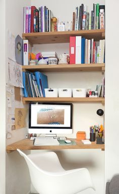 a computer on a desk in front of a bookshelf