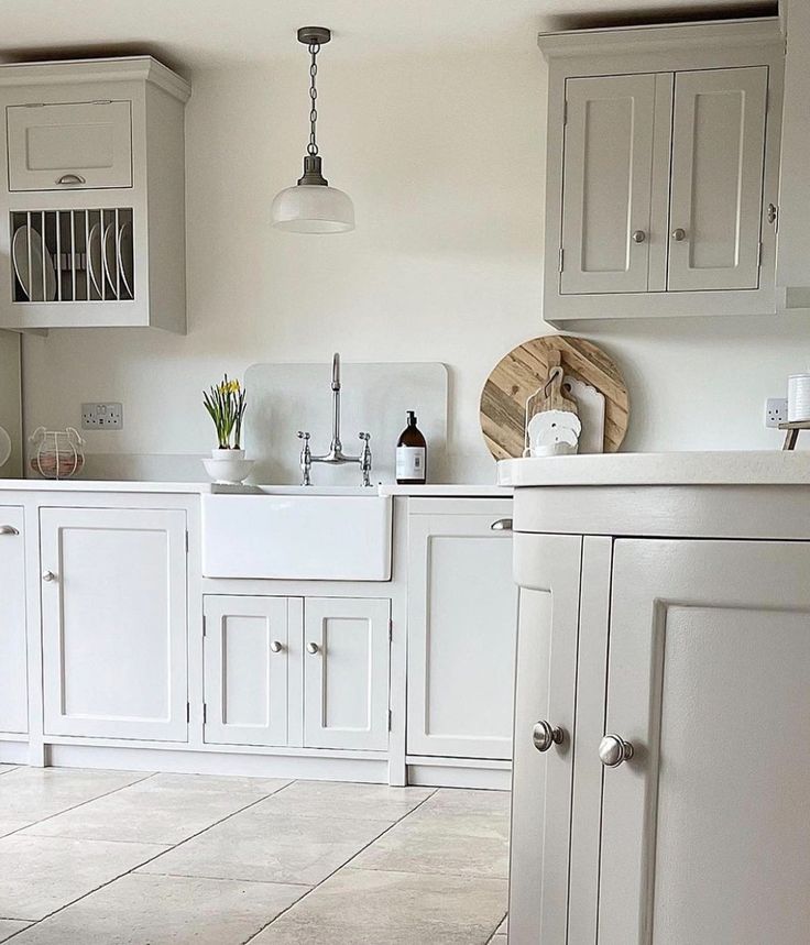 a kitchen with white cabinets and tile flooring