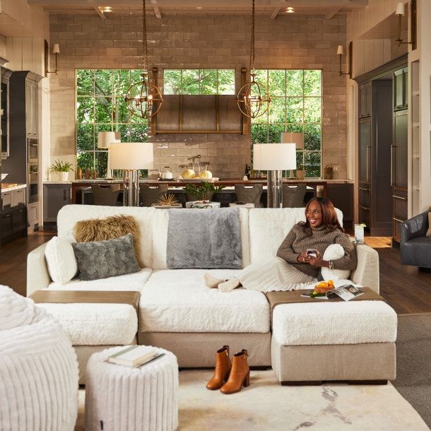 a woman sitting on top of a white couch in a living room