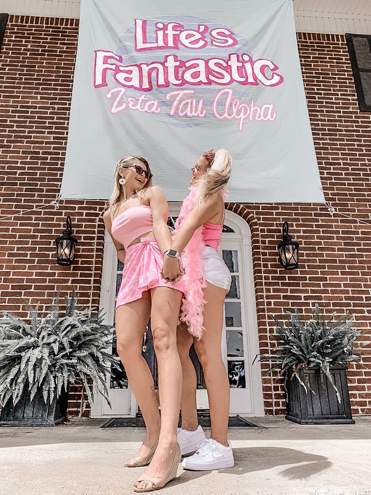 two women standing in front of a sign that says life's fantastic des tau alopia