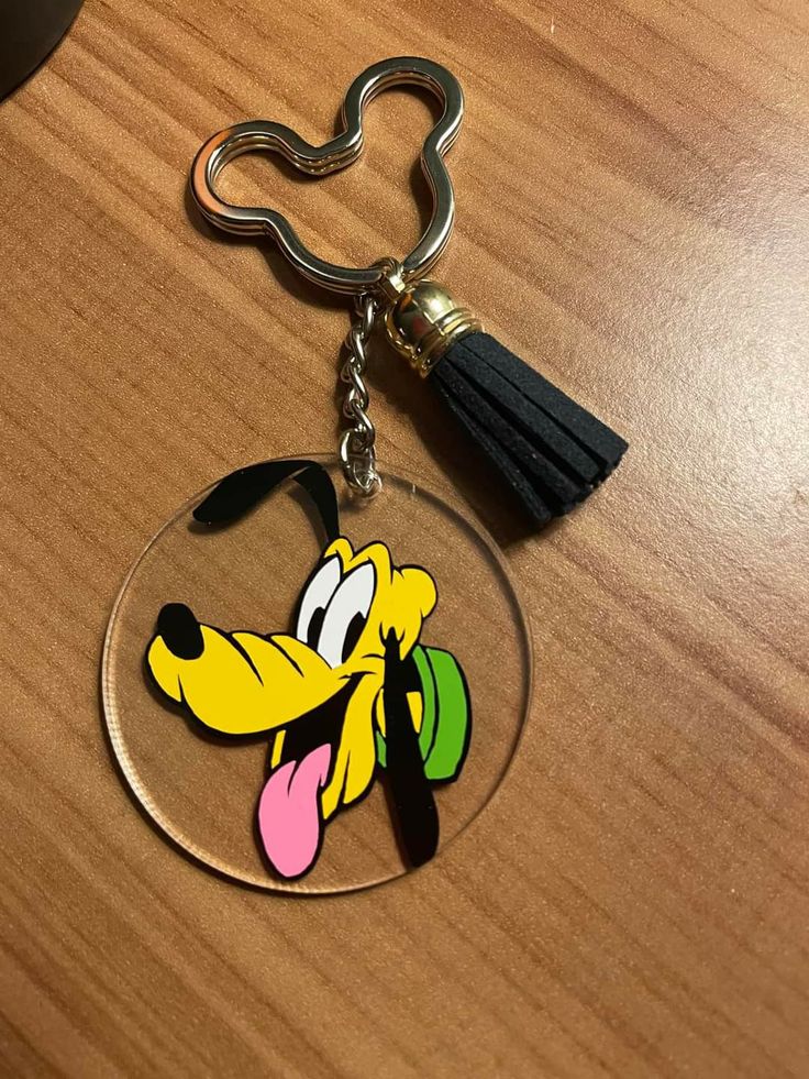 a cartoon character keychain with a tassel hanging from it's side