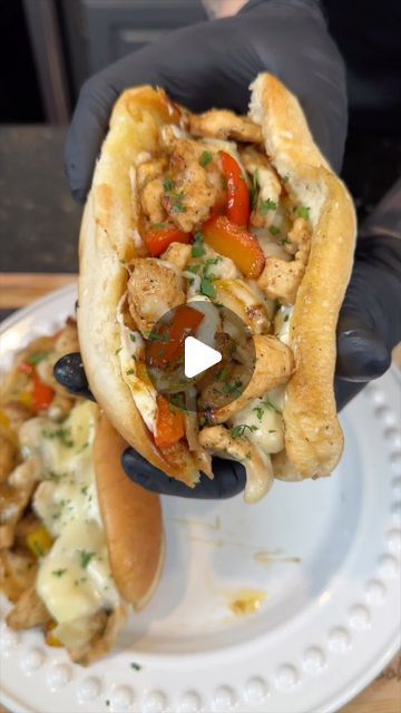 a person is holding a hot dog on a plate with some food in front of them