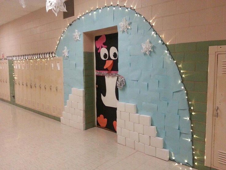 a decorated hallway in a school with snowflakes on the wall and a penguin door