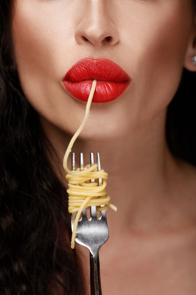 a woman holding a fork with spaghetti on it's end and red lipstick,