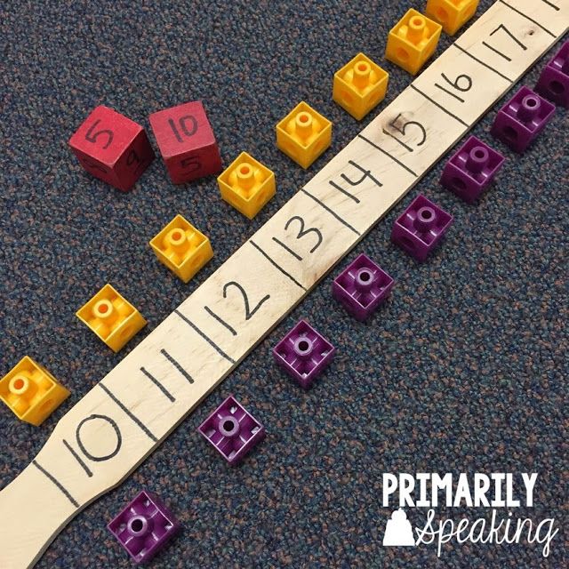 a ruler with numbers and cubes on it sitting on the floor next to some lego blocks