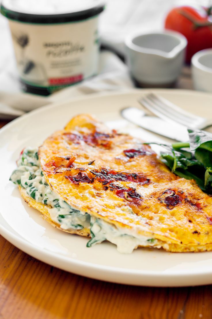 an omelet with spinach and cheese on a white plate