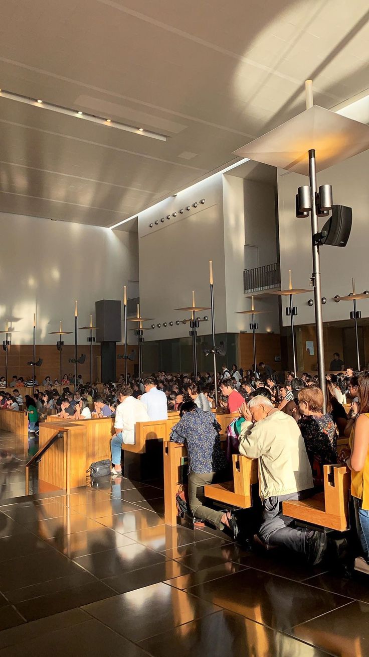 many people are sitting on benches in the church