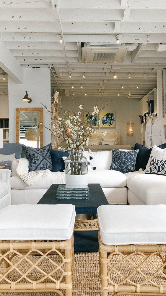 a living room filled with lots of white furniture and pillows on top of each other