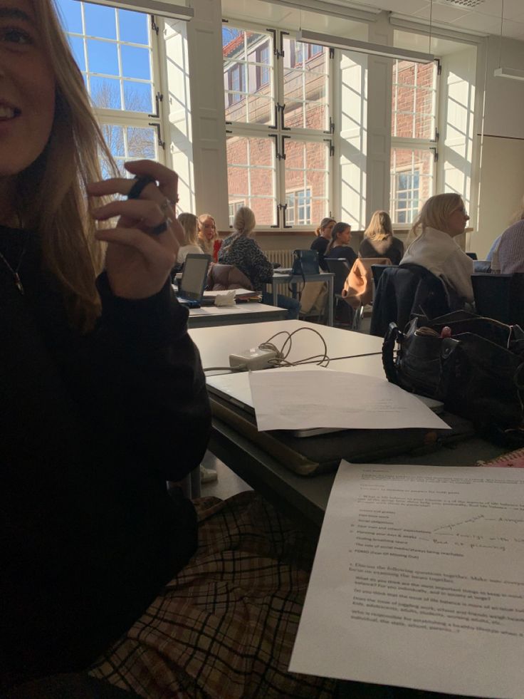 a woman sitting at a table holding a cell phone