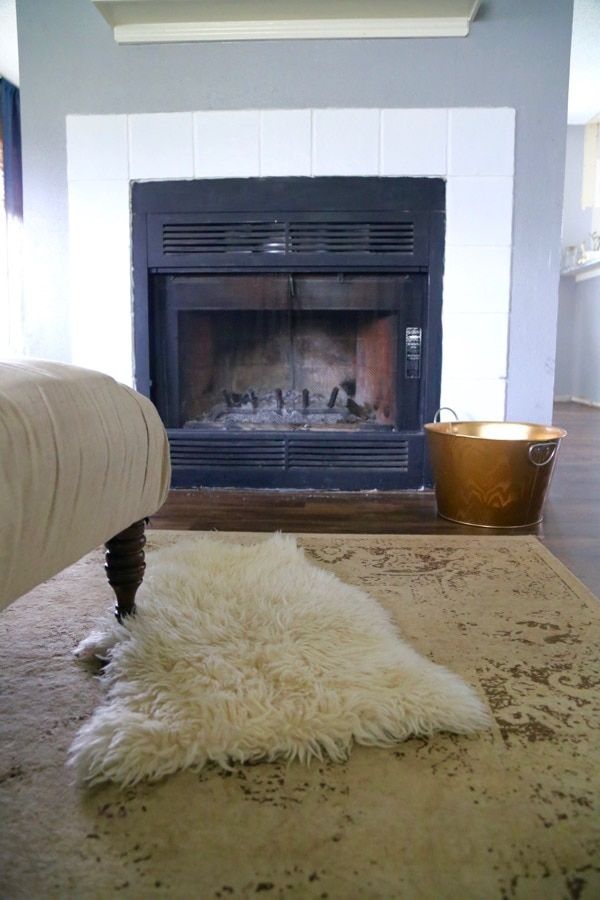 a living room with a fireplace and rug on the floor