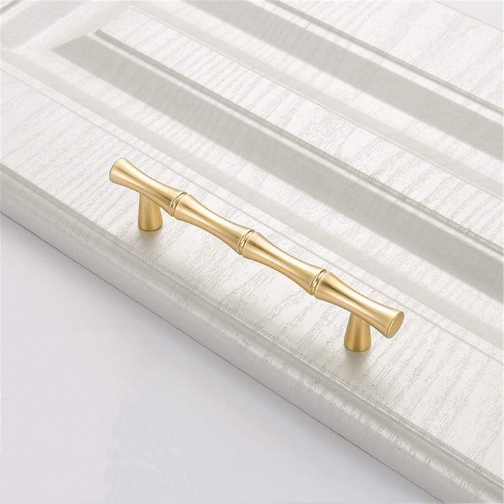 a close up of a gold handle on a white curtain