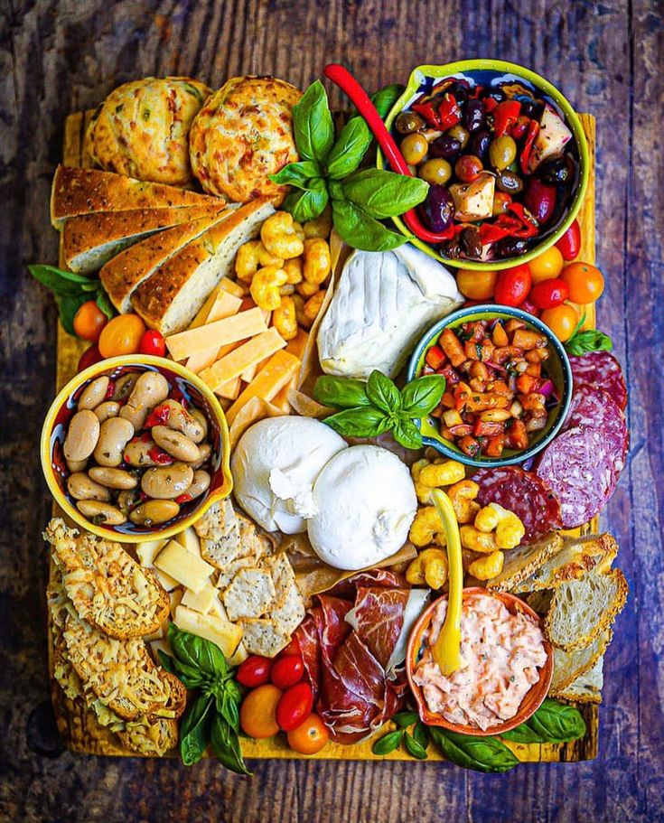 a platter filled with lots of different types of meats, cheese and vegetables