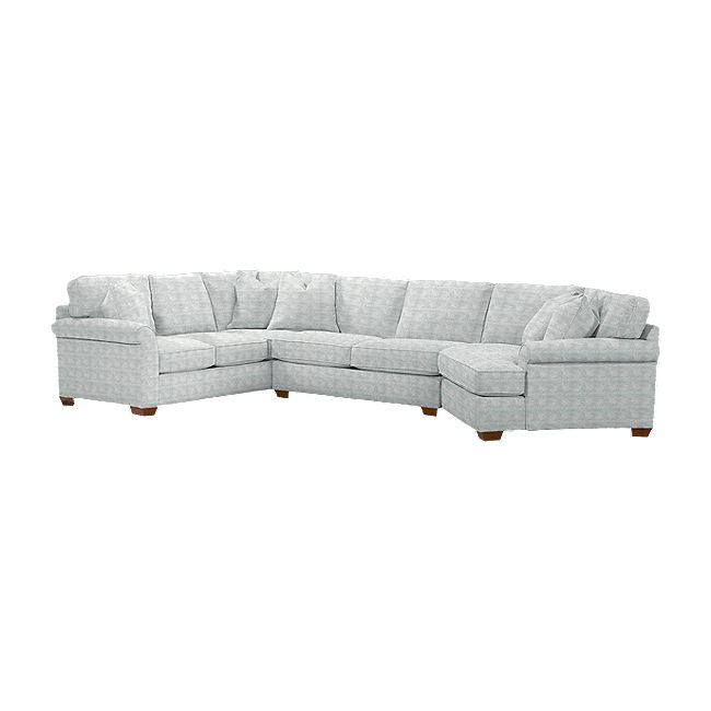 a white sectional couch sitting on top of a white floor next to a wooden table