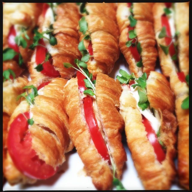 several croissants with red peppers and cheese on them are arranged in rows