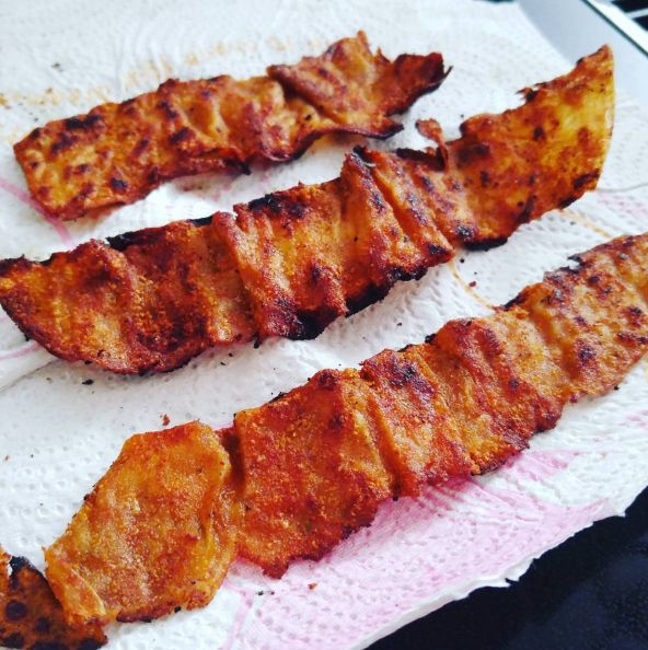 three pieces of meat sitting on top of a white paper towel next to each other