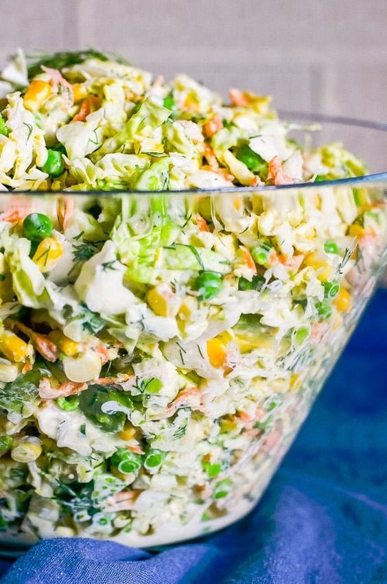 a salad in a glass bowl on a blue cloth