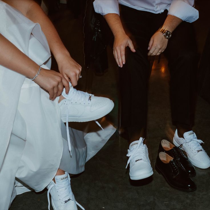 two people tying white shoes on the floor