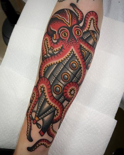 an octopus tattoo on the left arm and shoulder is shown in red, black and grey colors