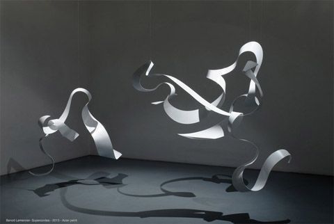 an abstract sculpture in the middle of a room with shadows on the floor and walls