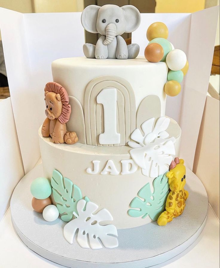 a birthday cake with an elephant and giraffe on top