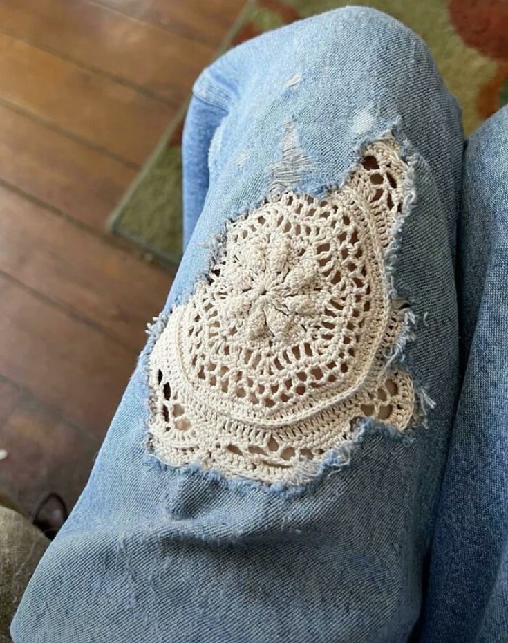 someone is wearing jeans with crocheted patches on the bottom and side, while they both have holes in them