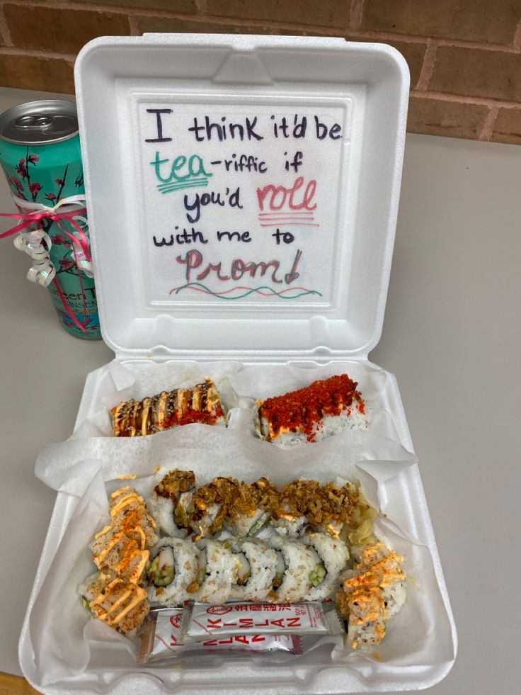 a take out box filled with sushi and other food on top of a table