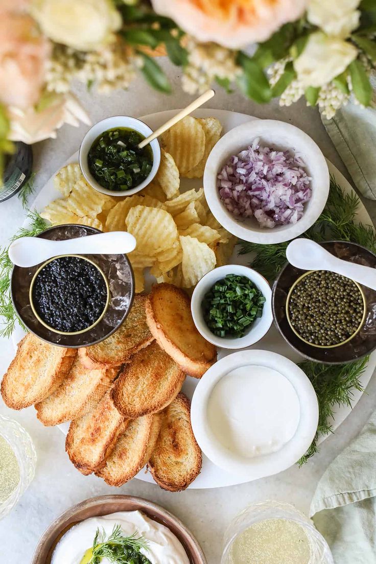 an assortment of food on a plate with dipping sauces and other condiments